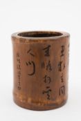 A Chinese bamboo brush pot: of cylindrical form, with rows of calligraphy to the sides, 13cm.