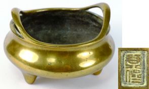 A Chinese bronze tripod censer: with swept loop handles to the sides and character mark to the