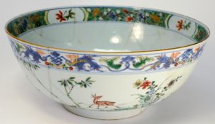 A Chinese porcelain punchbowl: decorated in the famille verte palette, the exterior with deer and