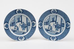 A pair of Chinese blue and white plates: each painted with a dignitary and a servant holding a