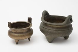 Two Chinese bronze tripod censers: both with loop handles above a waisted neck and rounded body,