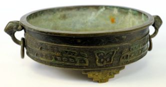 A small Chinese bronze tripod censer: of oval form with ram`s head handles hung with loose rings,