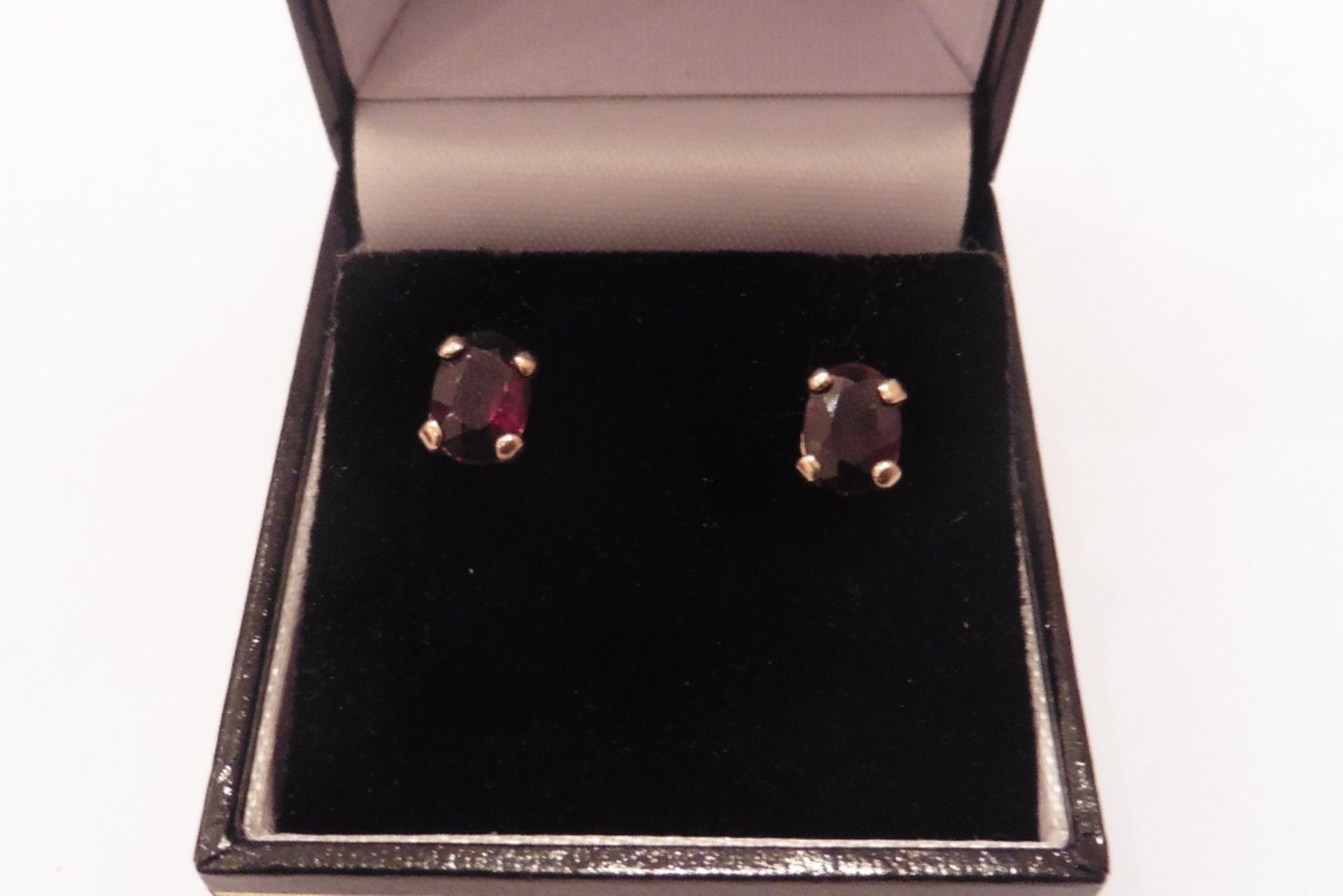 Pre-owned 9ct yellow gold red garnet stud earrings with oval cut stones, simple claw setting. Standa
