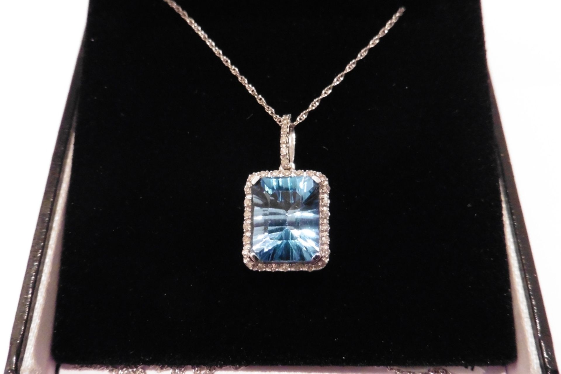 Modern 9ct white gold blue topaz and diamond pendant set with a single emerald cut blue topaz of bea