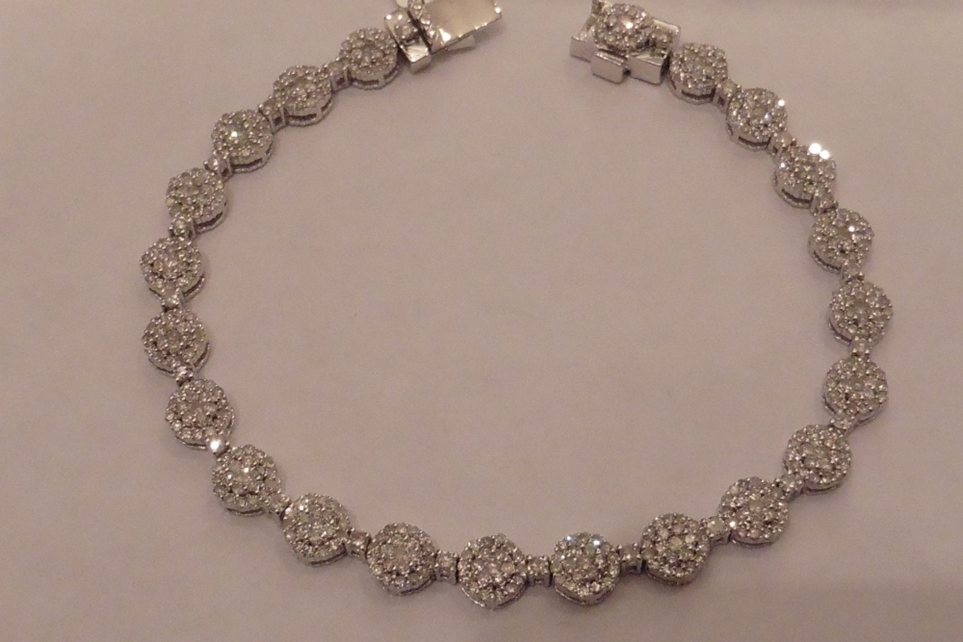 9ct white gold fancy diamond bracelet set with clusters of small round cut diamonds of I1/I2 clarity