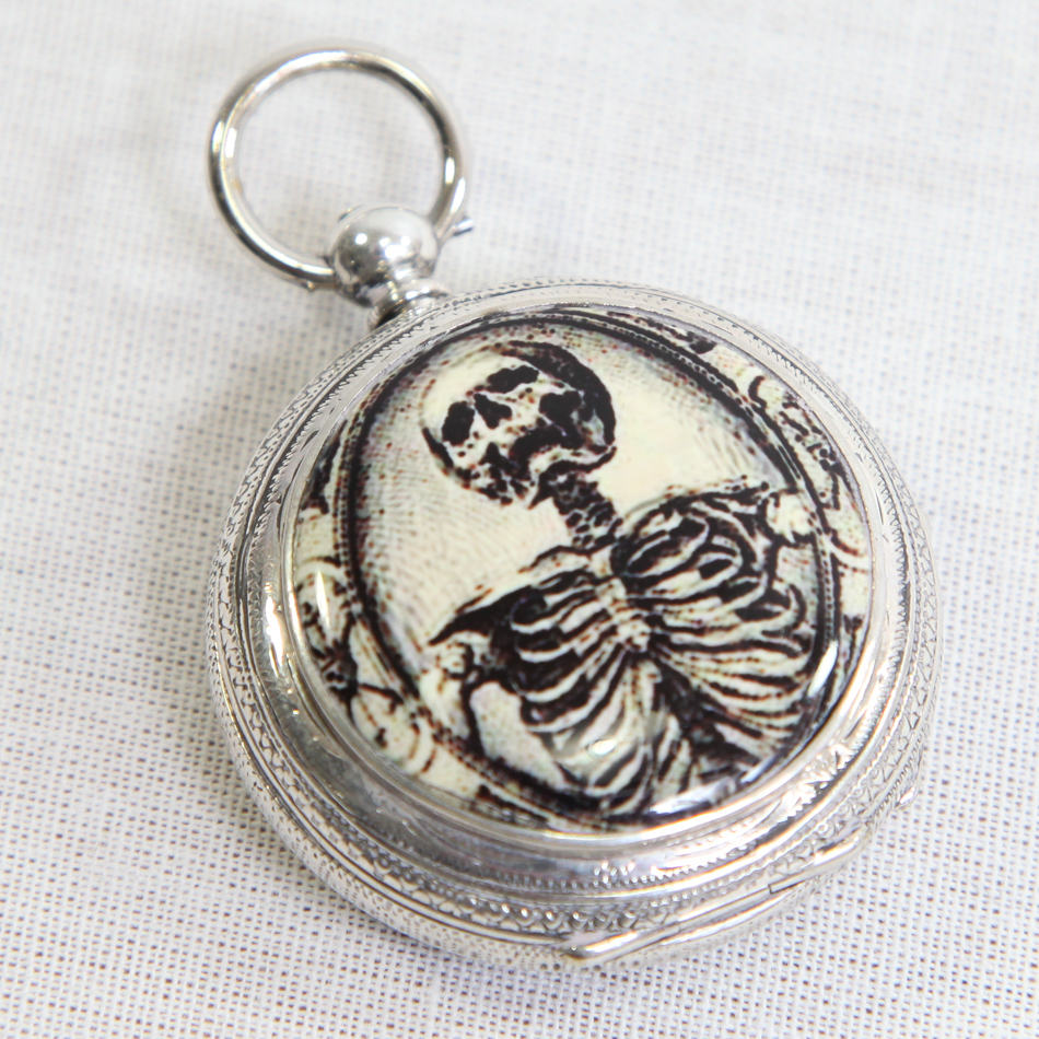 Small pocket watch with white coloured metal case, applied enamel decoration of a skeleton to the