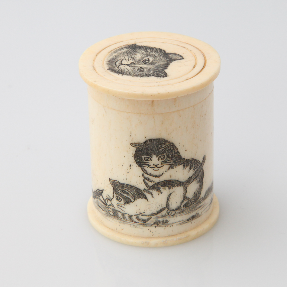 Small bone dice box, cylindrical form, etched with cats and containing dice, 4.5 cm high