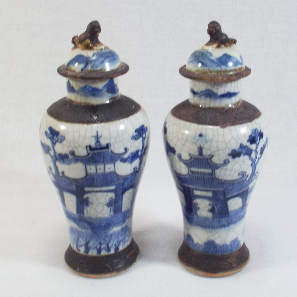Pair of oriental blue and white crackle glaze stoneware vases with covers, one vase with restoration