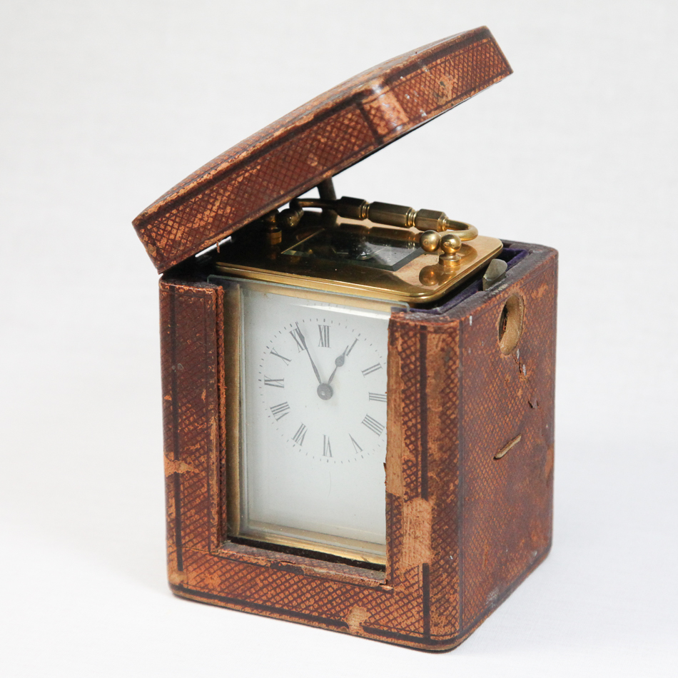 Small brass and glass case carriage clock, 9.5 cm high with handle, with leather bound travelling