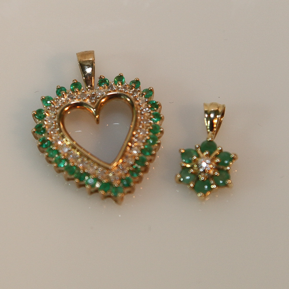 2 9ct yellow gold emerald and diamond pendants, one a flower shape the other an open heart