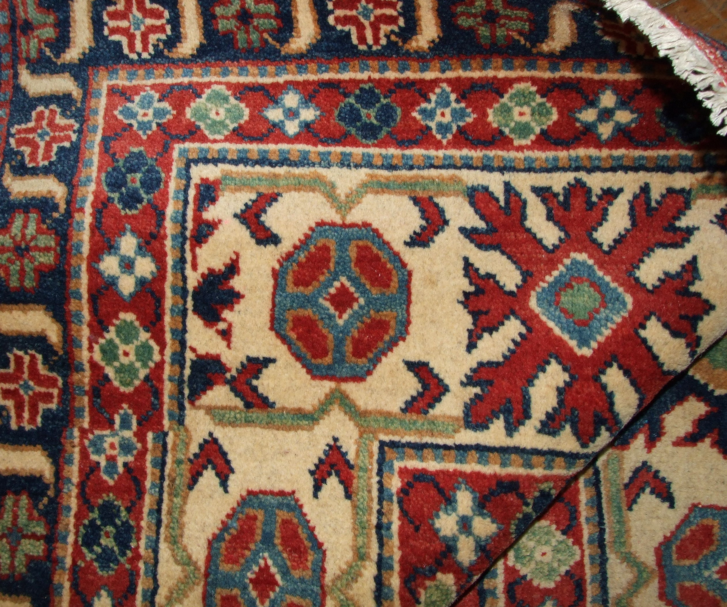 A Kazak carpet, with geometric motifs, on a red ground, within a multi border, 293 x 197 cm