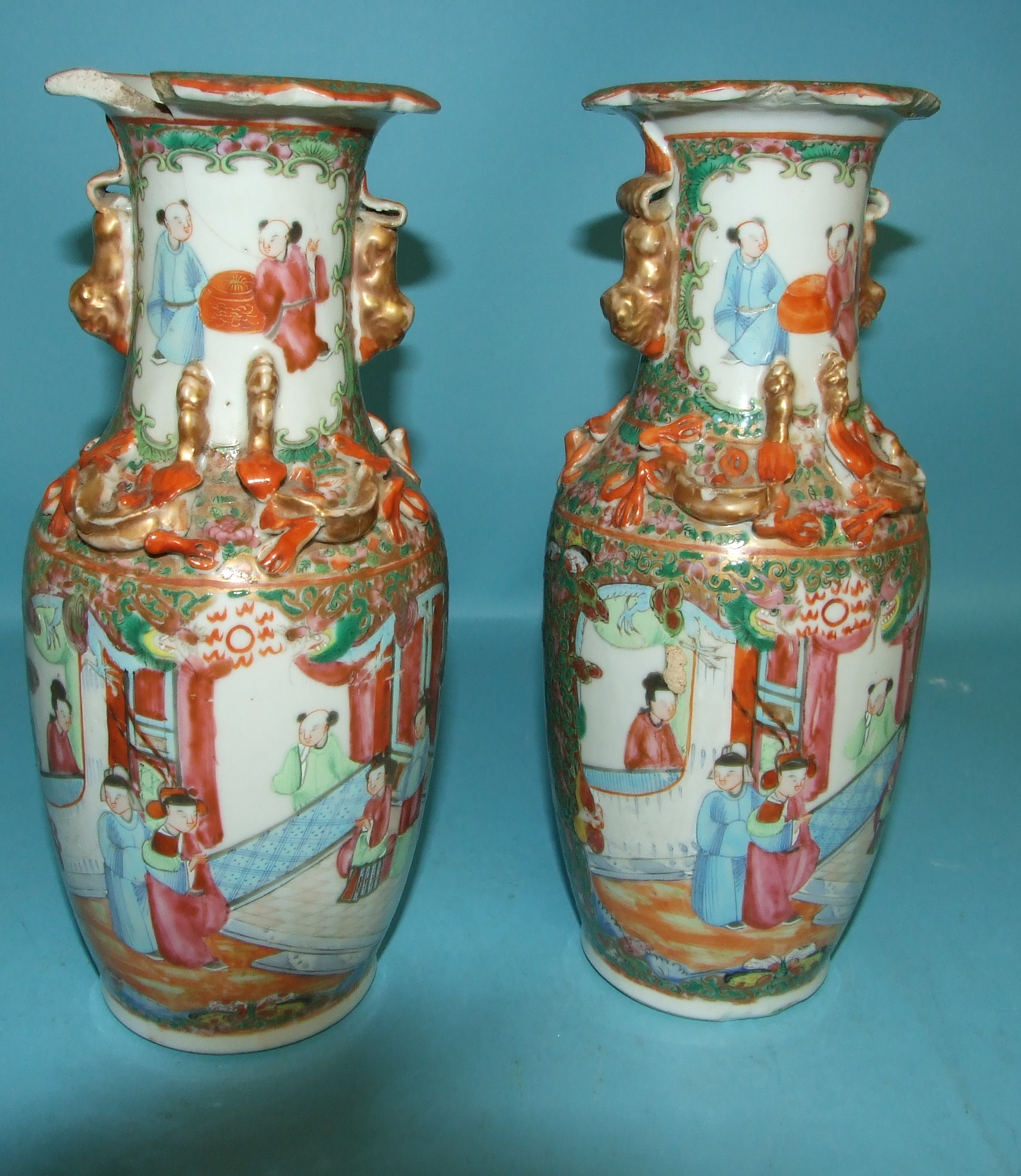 A pair of Cantonese famille rose vases, decorated figures, 25 cm high (a.f.) (2)