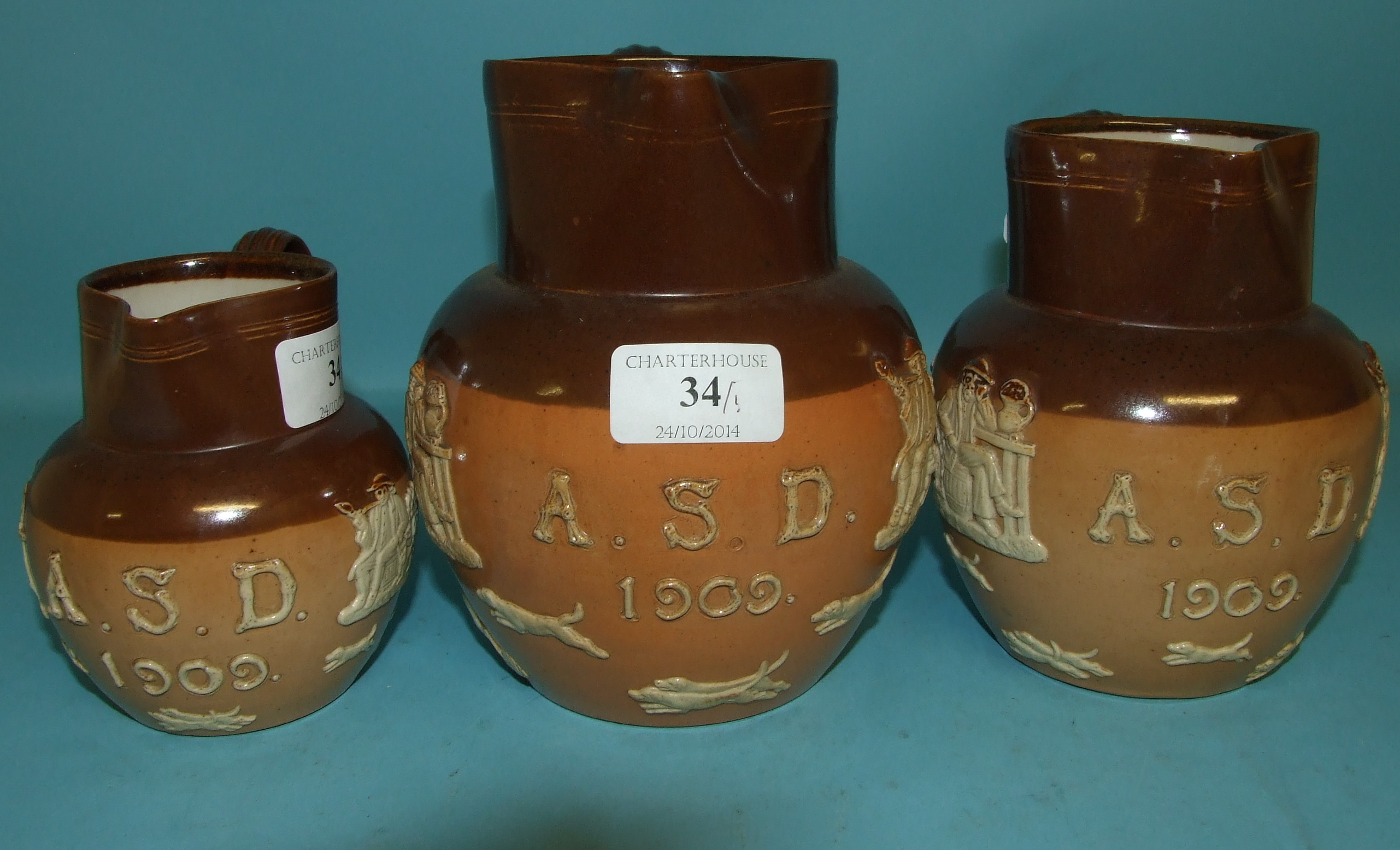 A set of three graduated Royal Doulton stoneware jugs, initialled and dated 1909, 8553, the
