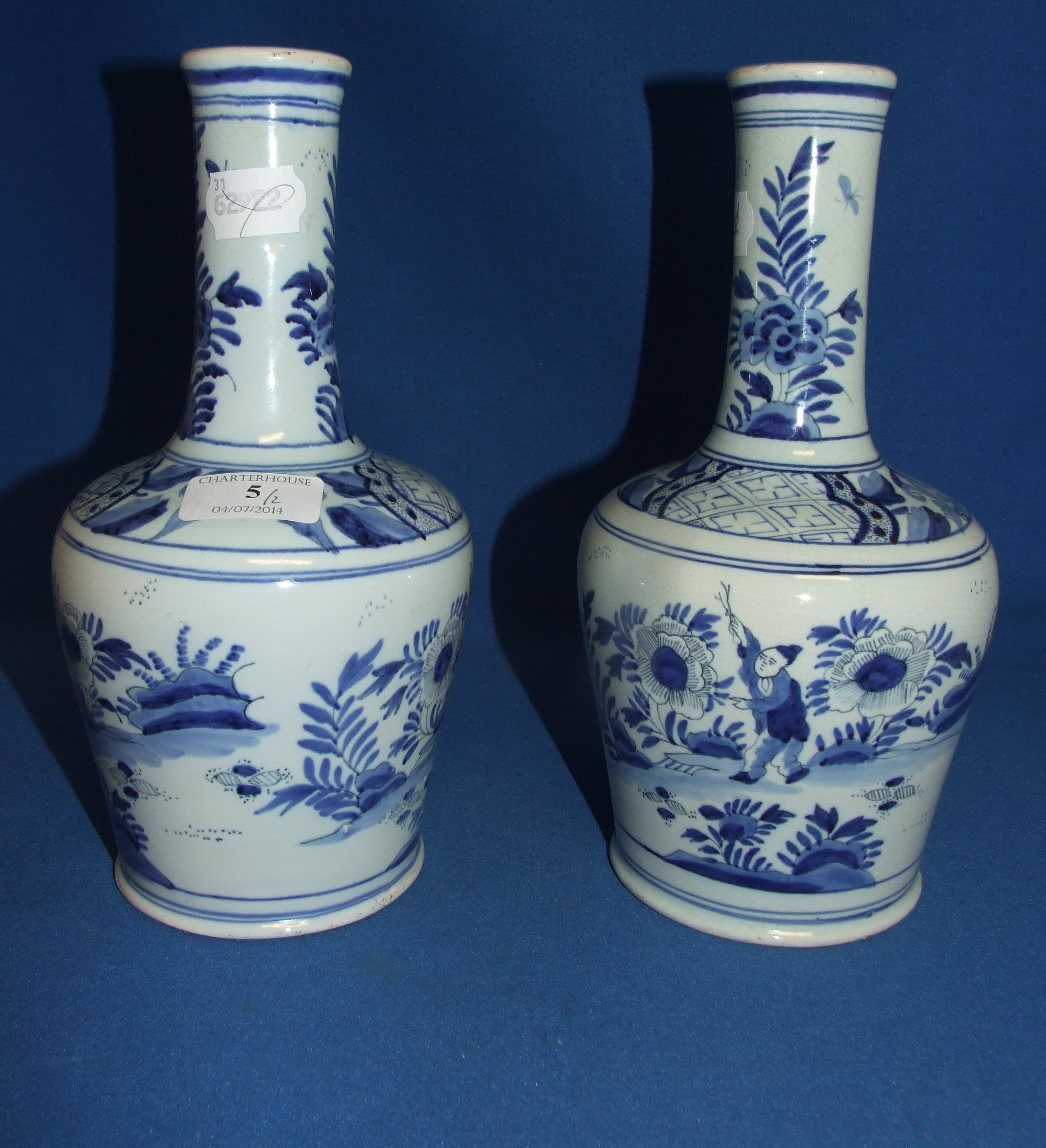 A pair of Delft pottery vases, decorated figures, 25 cm high (one chipped) (2)