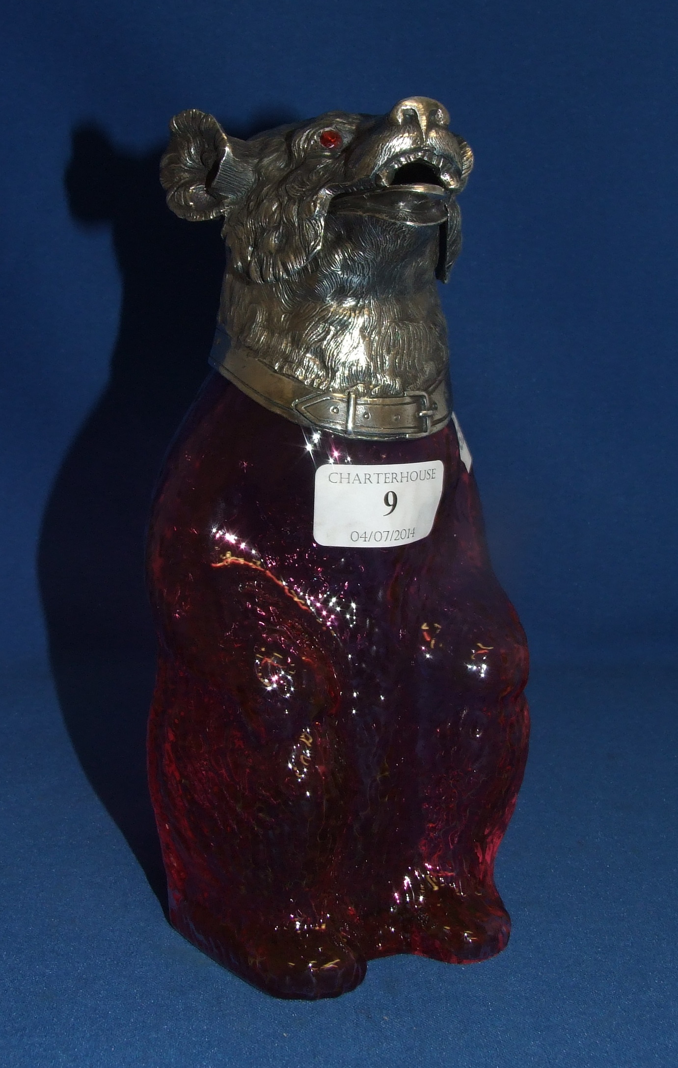 A ruby glass decanter, in the form of a bear, with silver plated mounts, 23 cm high