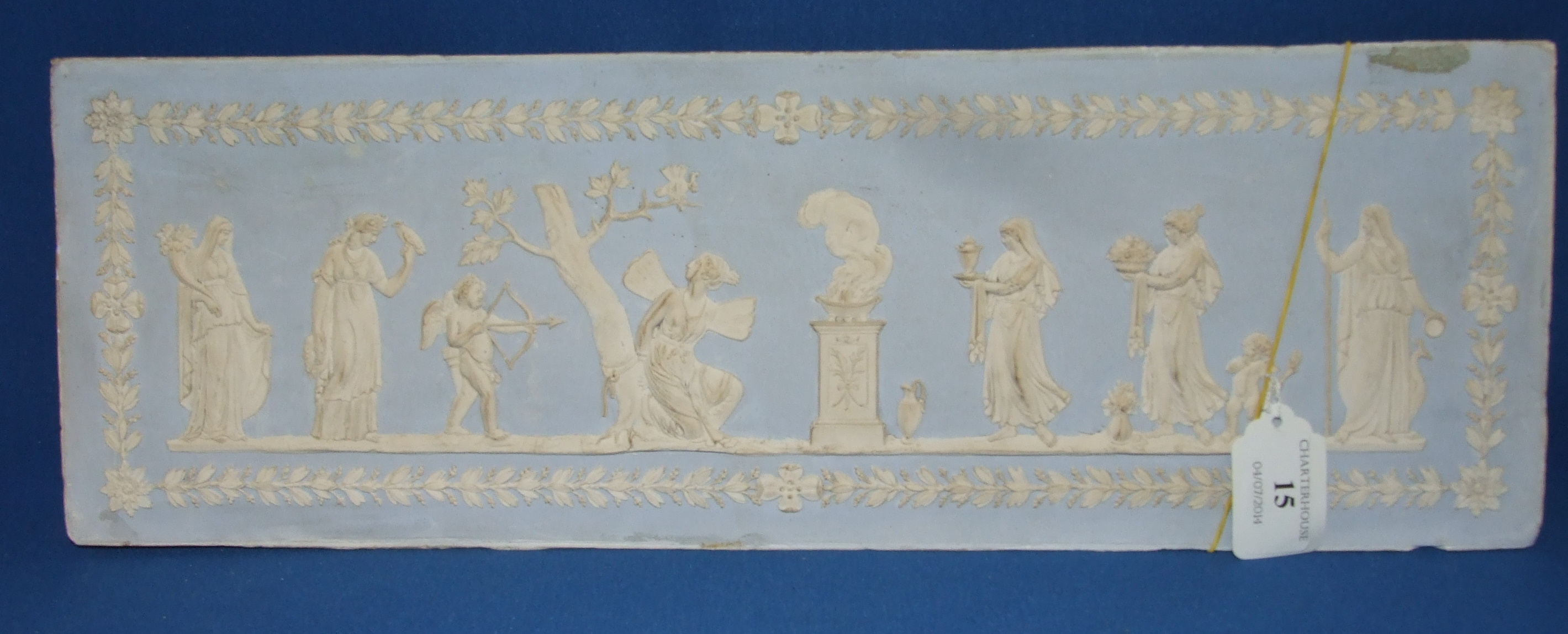 A plaster panel, decorated figures in relief, 15.5 x 46.5 cm