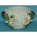 A Continental porcelain jardiniere, applied flowers and leaves, with branched handles (chipped),