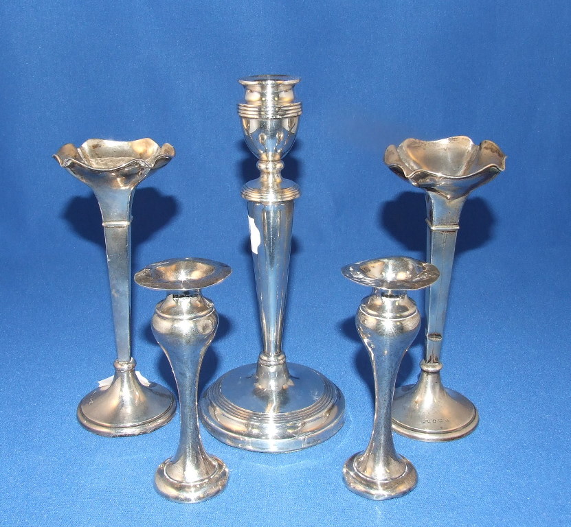 A pair of silver spill vases, Birmingham 1912, two candlesticks, silver topped jars and other