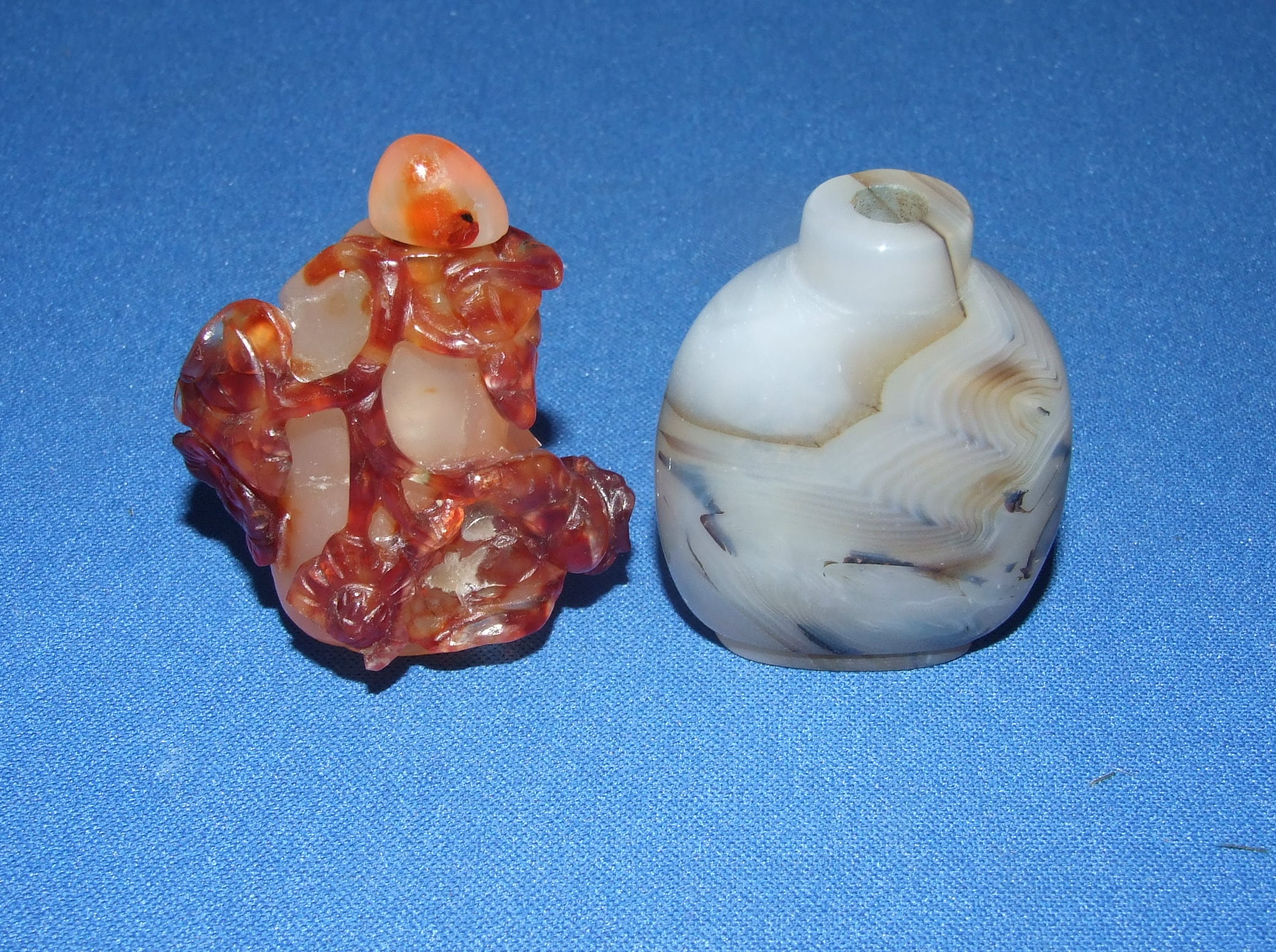 A hardstone snuff bottle, with carved decoration, 6 cm high, and another similar (2)