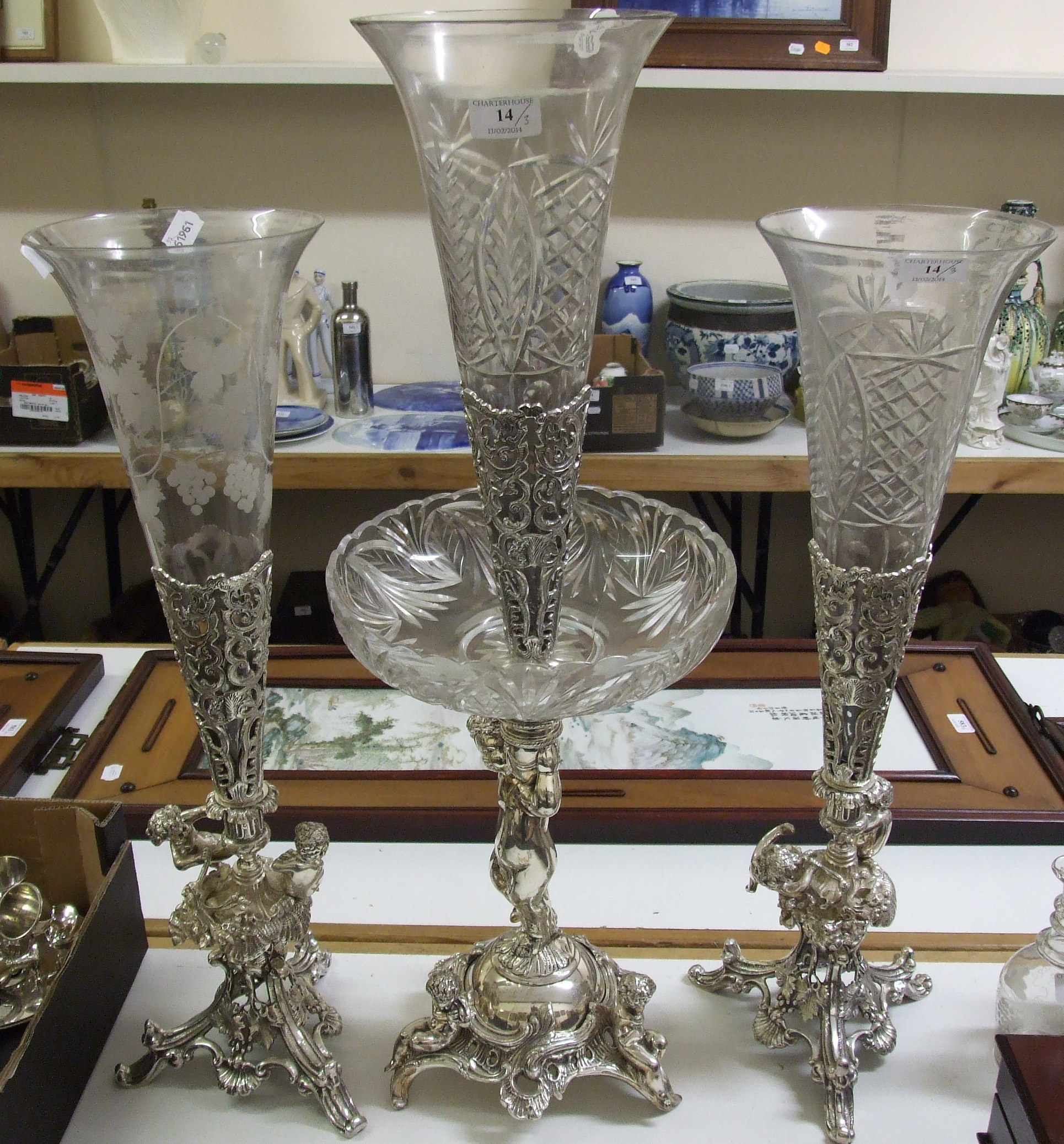 A glass and silver plated garniture of vases, with putto figural supports and rococo style