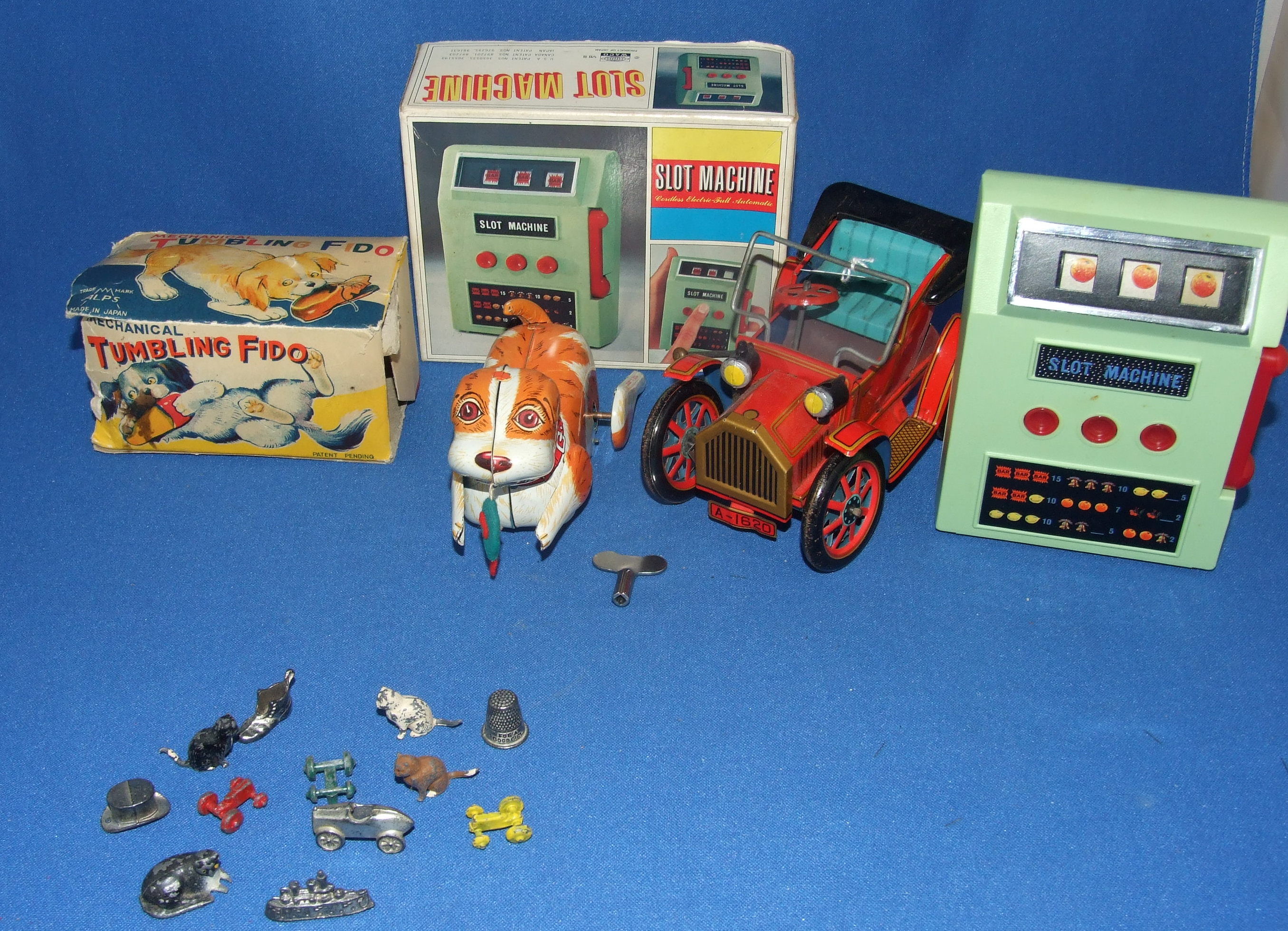 An Alps Mechanical Tumbling Fido, a slot machine, a tinplate vehicle, and other items (qty)