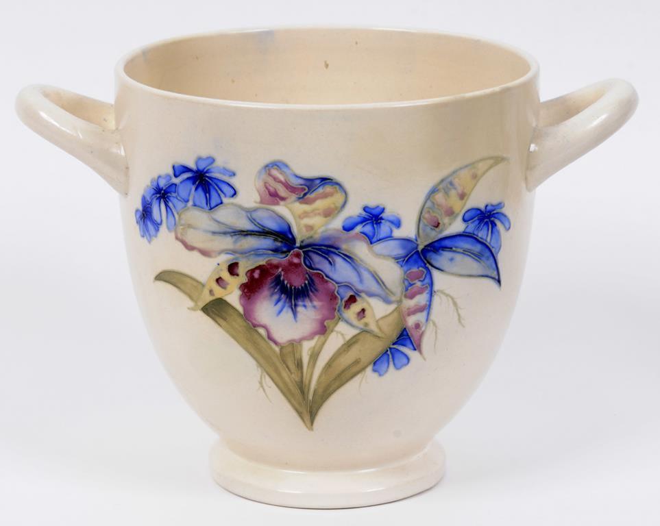A Moorcroft pottery two handle vase, decorated orchids on a white ground, the base impressed W