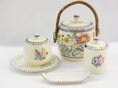 A Poole pottery biscuit barrel, with scrolling floral decoration on an ivory ground, purple and