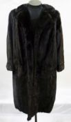 A dark full-length mink coat with embroidered lining