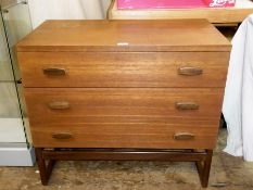 G-Plan chest of three long drawers, with wooden handles, on straight supports united by