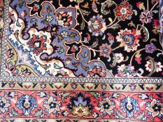 Persian wool rug with central flowerhead medallion, on midnight-blue field, with allover scrolling