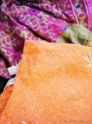A orange sequinned sari, four various Indian scarves, a green/cerise embroidered Indian skirt and