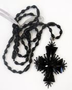 A black jet and metal cross pendant on jet-type kidney and oval-shaped bead long necklace
