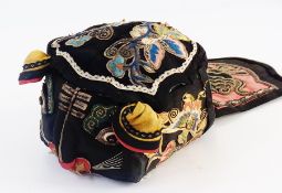 A Chinese silk embroidered hat, black silk embroidered with a cat face, with a label with a