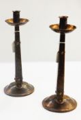 A pair of Arts & Crafts copper candlesticks, tapered on circular base with stud relief detail,