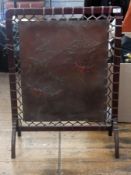 Arts & Crafts oak firescreen with leather panel, with relief decoration of branches with berries,