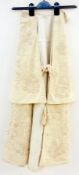 A child's cape, cream with ribbon tie, silk lining (af), foliate embroidered with tassels