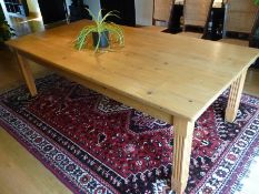 A large pine dining table, 244cm x 181cm with stout fluted legs