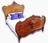 A French walnut double bed, the shaped head and foot boards with carved and moulded finial and other
