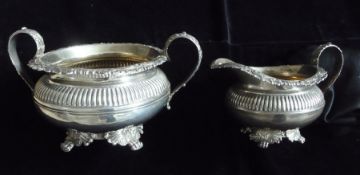 A George IV silver two-handled sugar bowl with reeded border, applied foliate mouldings, four scroll