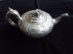 A William IV silver bullet-shaped teapot having 'c' scroll and floral embossed decoration and