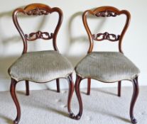 A pair of Victorian mahogany dining chairs having shaped crest rail, carved and pierced horizontal