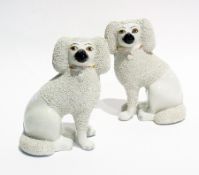 A pair of Staffordshire-style pottery chip-coated model poodles, 21cm high