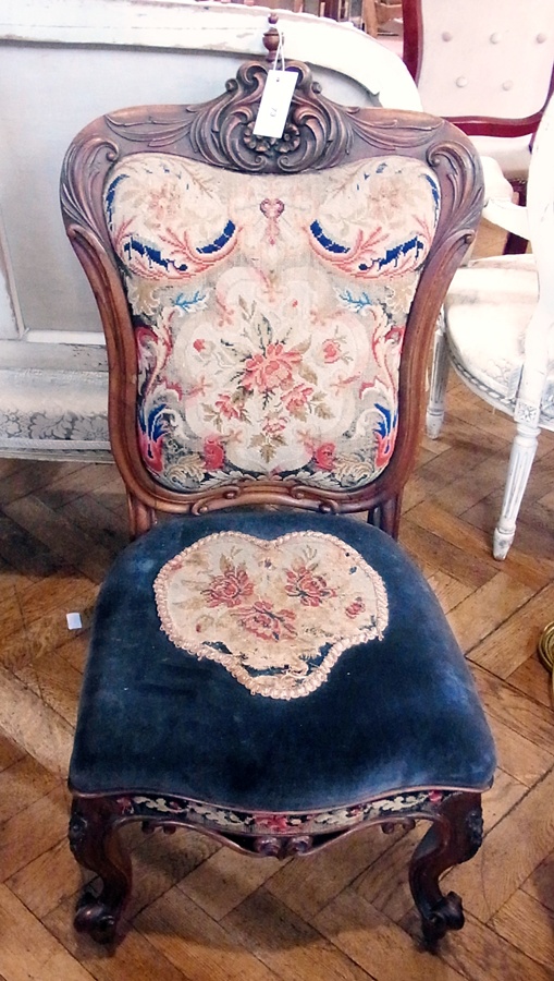 A Victorian carved rosewood nursing chair with foliate carving, needlework panels and seat, raised