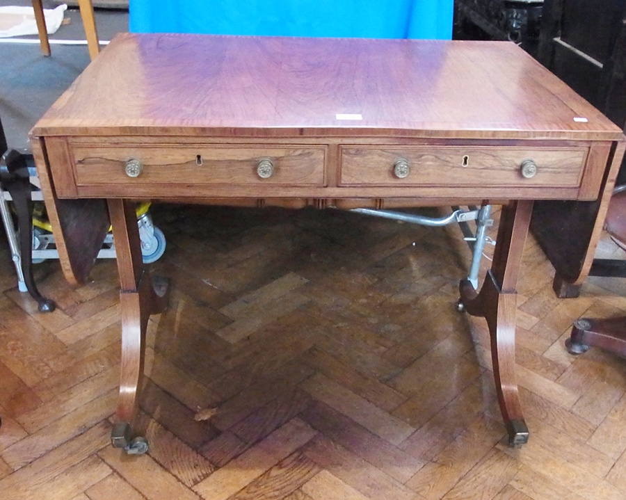 An early 19th century rosewood sofa table, the rectangular top with rounded corners and cross