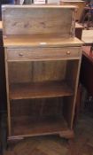 A 20th century oak freestanding shelving unit with single drawer and shelf, on bracket feet (af -