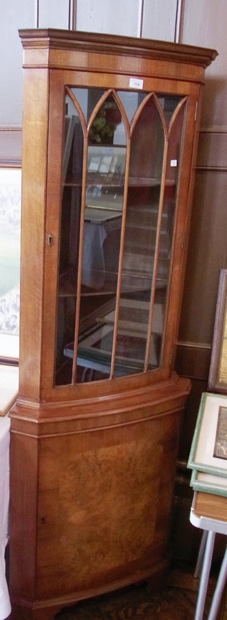 A modern figured walnut corner cabinet, astragal-glazed door, to cupboard below, on bracket feet,