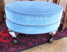 An upholstered oval stool, on short cabriole legs with claw and ball feet, length 66cms