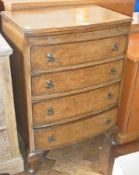 A walnut veneer bow front bachelor's chest of drawers, with moulded edge top with brushing slides