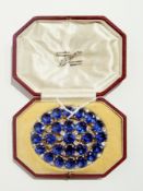 A large blue and white stone cluster Sari brooch of oval design in white metal setting, in fitted "M