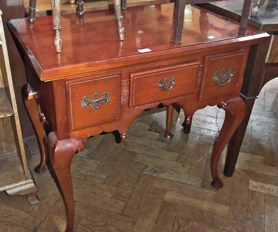 A reproduction mahogany lowboy with three drawers, with brass swan-neck handles, on cabriole